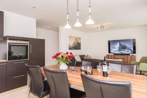 a kitchen and dining room with a table and chairs at Ferienhaus Casa Luna in Zermatt