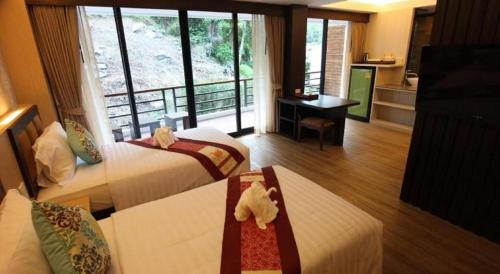a hotel room with two beds and a kitchen at Phi Phi Nice Beach Hotel Hip in Phi Phi Don