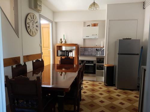 une cuisine avec une table et un réfrigérateur dans l'établissement Maison ville 4 à 8 personnes MHP, à Lons-le-Saunier