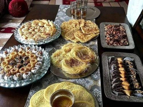 a table topped with different types of pies and pastries at imintanoute abderrahim in Oulad Akkou