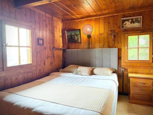 a bedroom with a bed in a wooden wall at Authentique chalet familial in Nendaz