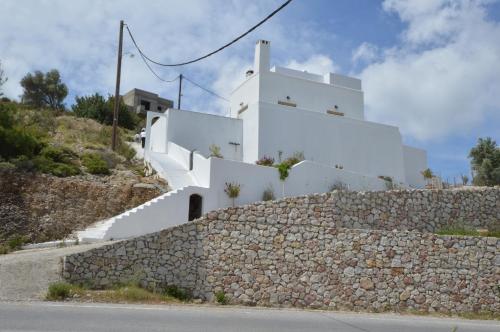 a building with white walls and a stone wall at Bianca Suite & Home in Psinthos
