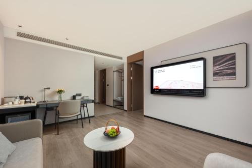 a living room with a flat screen tv on a wall at Atour Hotel Hangzhou Xiaoshan Kaiyuan Plaza in Xiaoshan