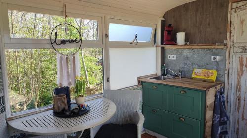 a kitchen with a table and a sink and a window at De PostKeet in De Cocksdorp