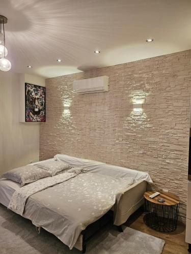 Ce lit se trouve dans une chambre dotée d'un mur en briques. dans l'établissement Spacious & Cozy - 3 Bedrooms, à Chasse-sur-Rhône