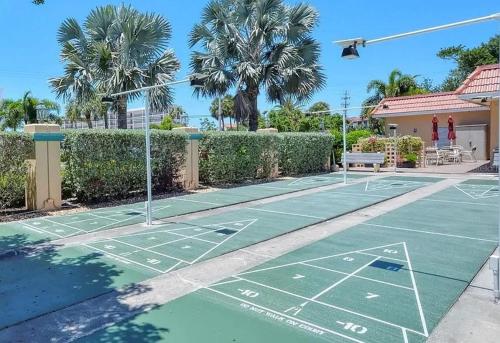 a tennis court in front of a house with palm trees at New Siesta Key Canal View in Siesta Key