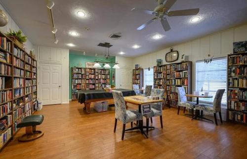 a library with a table and chairs and books at New Siesta Key Canal View in Siesta Key