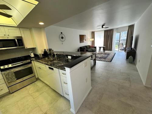 a kitchen with white cabinets and a living room at New Siesta Key Canal View in Siesta Key