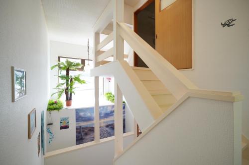 a staircase in a house with white walls at kawana To the Beach in Ito