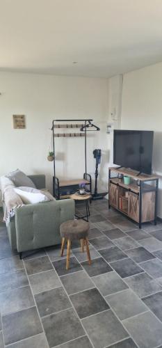 a living room with a couch and a flat screen tv at Le petit Marius in Fayence