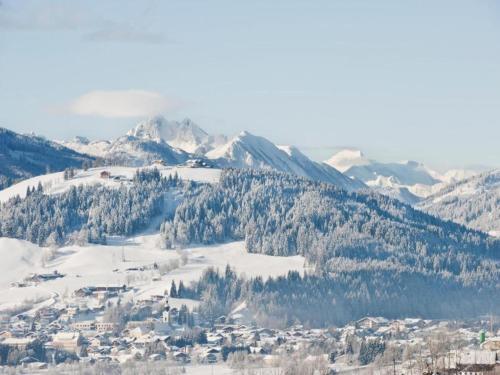 a town on a snowy mountain with snow covered mountains at Apartment in Maishofen near Ski Slopes in Maishofen