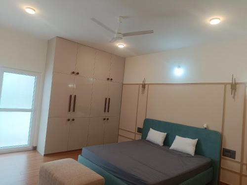 a bedroom with a bed and cabinets and a window at Chandra in Bengaluru