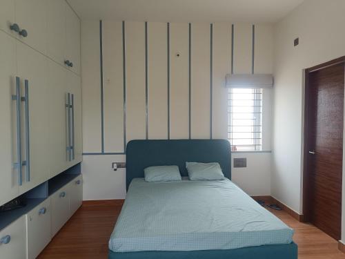 a bedroom with a bed and a window in it at Chandra in Bengaluru