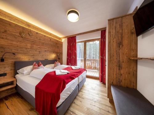 ノイキルヒェン・アム・グロースヴェンエーディガーにあるChalet in Neukirchen near Ski Liftのベッドルーム1室(ベッド2台、赤毛布付)