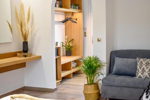 a living room with a blue chair and plants at Giabeos Skiathos in Troulos