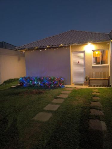 a house with a white door and flowers in the yard at Casa perto da UFSCar - Refugio perfeito in São Carlos