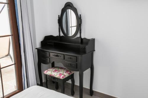 a black dresser with a mirror and a stool at Hostal Boutique Bajamar in Nerja