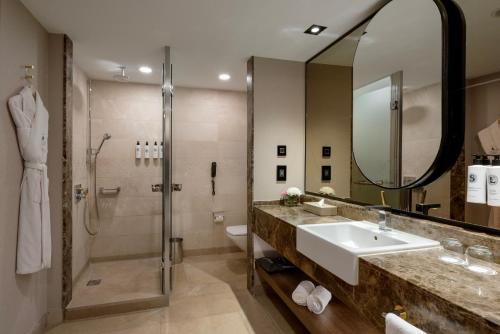 a bathroom with a sink and a shower at Kempinski Hotel The Dome Belek in Belek