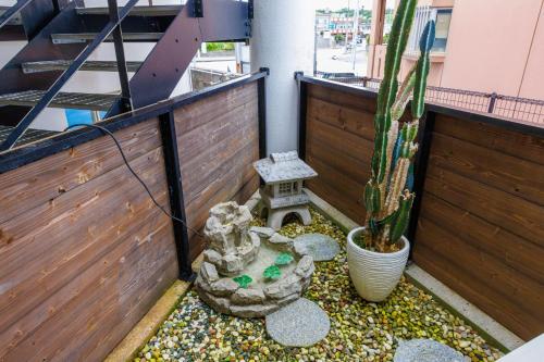 a small backyard with a cactus and a garden at 駐車場2台 海中道路や伊計島にアクセス良好 和室付き 最大5名宿泊施設 Guest house mum in Uruma