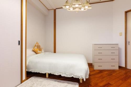 a bedroom with a mirror and a bed and a dresser at 駐車場2台 海中道路や伊計島にアクセス良好 和室付き 最大5名宿泊施設 Guest house mum in Uruma