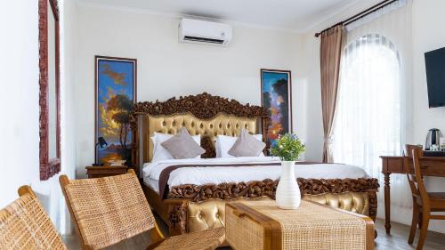ein Schlafzimmer mit einem Bett, einem Tisch und Stühlen in der Unterkunft Padi Heritage Hotel in Karangjepun