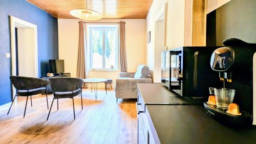 un salon avec un canapé, une table et des chaises dans l'établissement T3 Nature et Balnéothérapie, à Gérardmer