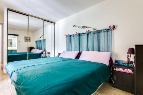 une chambre avec un grand lit et un miroir dans l'établissement Le Rayon de Soleil, à Martigues