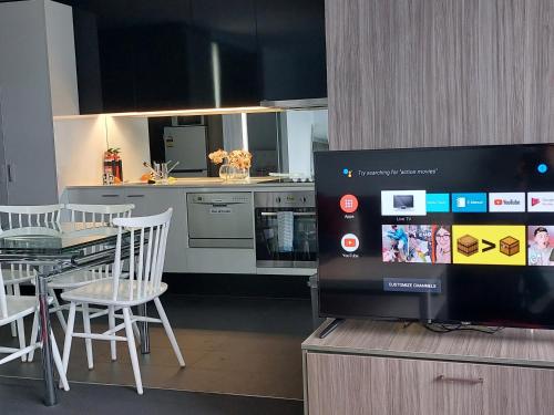 a kitchen with a table and a tv on a cabinet at Melbourne Single family apartment 2Br 2Bth Indoor Pool Sauna in Melbourne