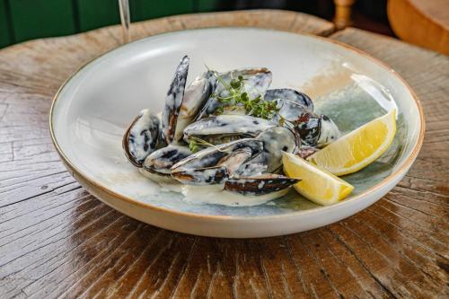 a plate of mussels and lemon slices on a table at Orbi City Luxury SUITE in Batumi