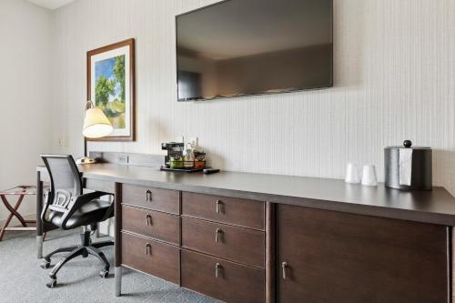 a desk in a room with a chair and a mirror at The Hotel Warner in West Chester