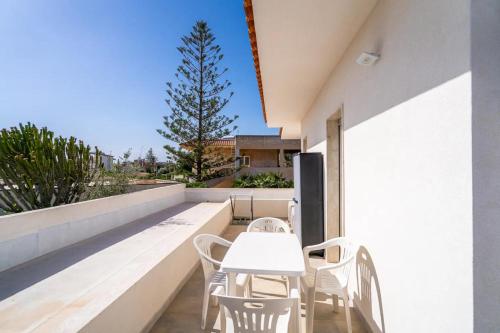 a white table and chairs on the balcony of a house at Littiricci in Marzamemi