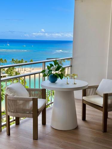 a table and chairs on a balcony with the beach at Panoramic Oceanview Resort - Full Kitchen in Each Unit, 2 Swimming Pools, Onsite Restaurants, Fireworks Every Friday in Honolulu