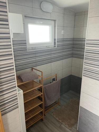 a small bathroom with a shower with a window at Apartma GoDeTi in Rečica ob Savinji