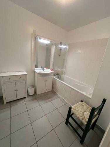 La salle de bains est pourvue d'un lavabo, d'une douche et d'une chaise. dans l'établissement Le Clos - Centre ville - Jardin - Parking privé, à Poitiers