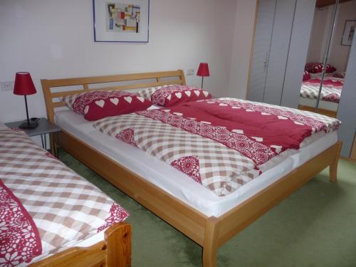 - une chambre avec 2 lits dotés d'oreillers rouges et blancs dans l'établissement Ferienwohnung Hans Ebner, à Eben im Pongau