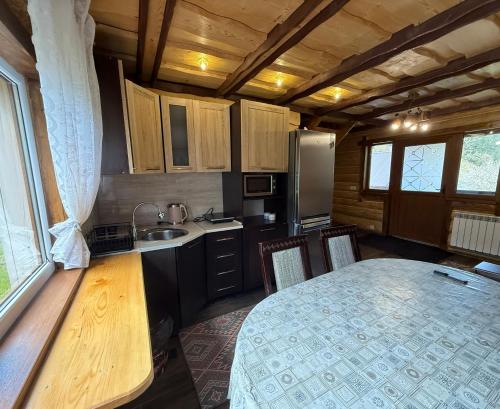 a small kitchen with a table and a sink at Котедж Під лісом in Synevyrsʼka Polyana