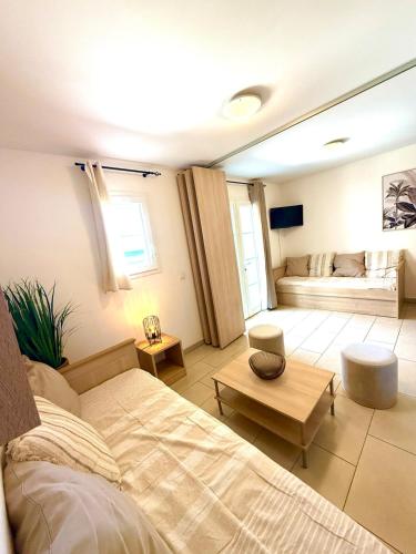 une chambre avec un lit et un salon dans l'établissement Appartement lumineux avec terrasse vue mer, à Sari-Solenzara