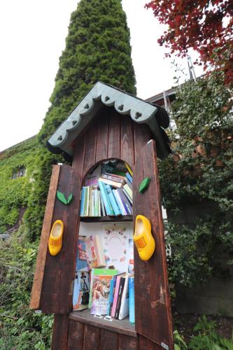 a book shelf in a wooden house with books at Hotel Weißes Roß in Altenbrak