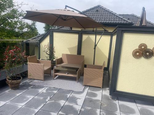 a patio with two chairs and an umbrella at Sorinas Home WB16 Top 7 in Wagersbach