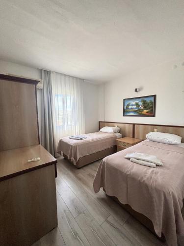 a hotel room with two beds and a window at Fora Apart Otel Cesme in Çeşme