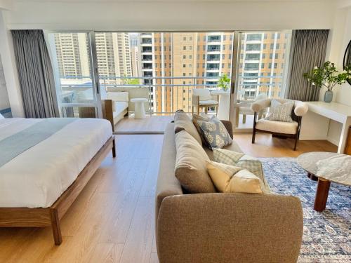 a living room with a bed and a couch in a room at Panoramic Oceanview Resort - Full Kitchen in Each Unit, 2 Swimming Pools, Onsite Restaurants, Fireworks Every Friday in Honolulu