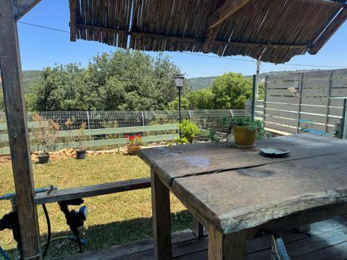 a wooden table with a bird standing next to a fence at שיר החורש in Shomera