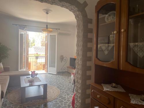 a living room with a table and a room with a window at Enetiko Apartments in Chios
