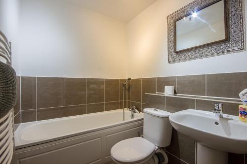a bathroom with a toilet and a sink and a tub at Serviced Lettings 2 Bedrooms Central Location On site Parking in Norwich