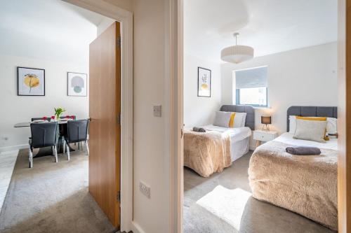 a bedroom with two beds and a table with a desk at Serviced Lettings 2 Bedrooms Central Location On site Parking in Norwich