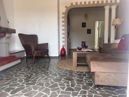 a living room with a couch and a chair at Enetiko Apartments in Chios