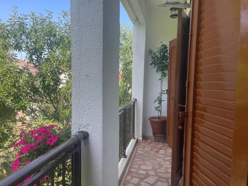 a balcony of a house with a door and flowers at Enetiko Apartments in Chios