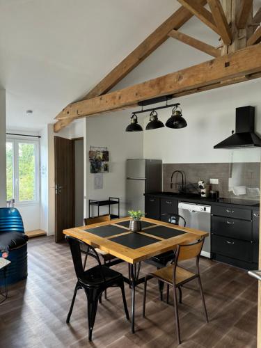 une cuisine et une salle à manger avec une table et des chaises dans l'établissement Chez Marylène, à Le Vanneau