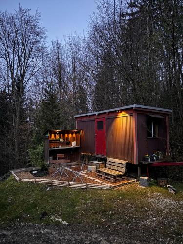 a small cabin with a red door in a field at Bauwagen mit Bergblick in Bad Reichenhall