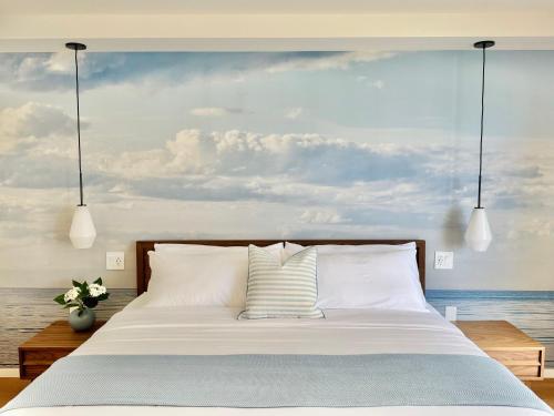 a bedroom with a bed with a painting of the ocean at Panoramic Oceanview Resort - Full Kitchen in Each Unit, 2 Swimming Pools, Onsite Restaurants, Fireworks Every Friday in Honolulu